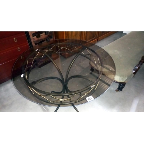 863 - A wrought iron table with smoke glass top, Diameter 75cm x 76cm high, COLLECT ONLY