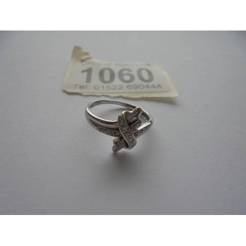 1060 - A diamond twist ring in 9ct white gold with diamond set shoulders, size K half.