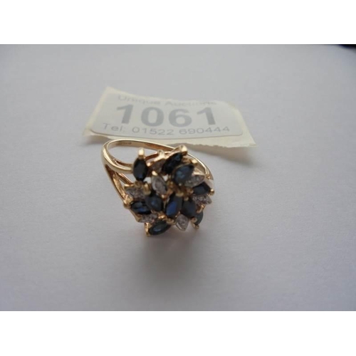 1061 - A sapphire and diamond cluster ring, marquise cut sapphires in 9ct gold size O.