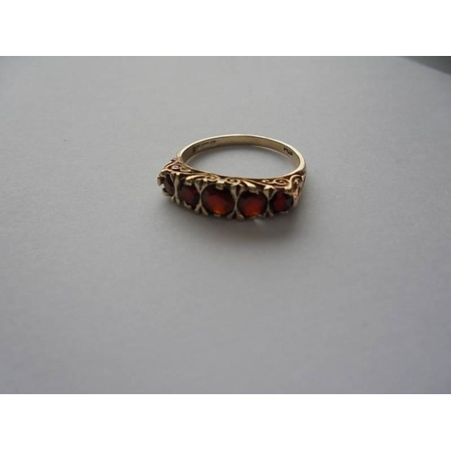 1063 - A garnet ring with five graduated stones, dated London 1981, size P.