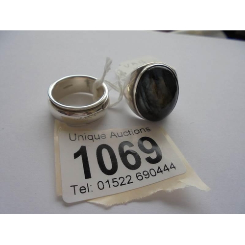 1069 - An oval heavy silver ring with a blue stone and a silver band or wedding ring,