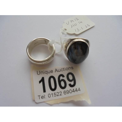 1069 - An oval heavy silver ring with a blue stone and a silver band or wedding ring,