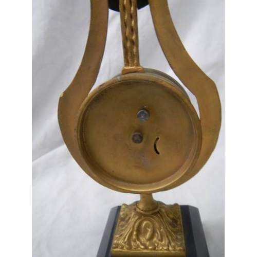 1076 - A brass lyre shaped mantel clock on slate base, a/f.