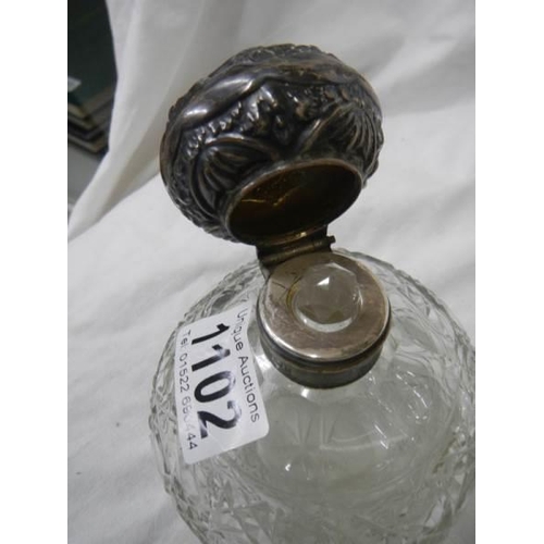 1102 - A silver topped perfume bottle and a glass jug with silver spout missing stopper.