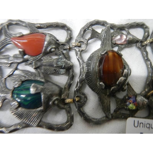 1116 - An antique metal bracelet featuring fish inset with various gem stones.