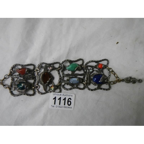 1116 - An antique metal bracelet featuring fish inset with various gem stones.