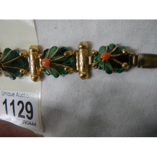 1129 - A yellow metal bracelet with flower shapes in green stone with red centre's (one red stone missing a... 