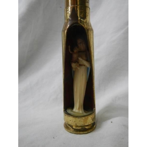 1130 - A item of trench art being a gun shell with figure of the Virgin Mary inside.