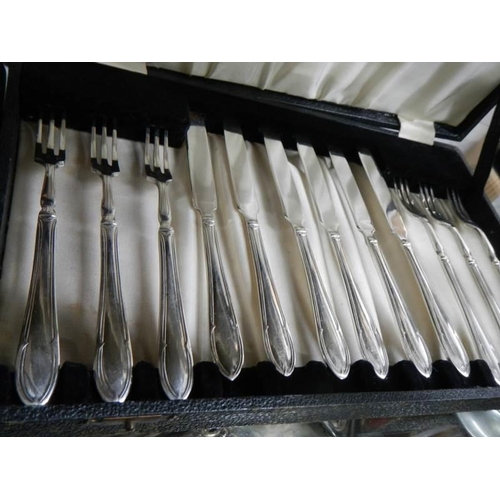 1298 - A cased set of dessert knives and forks and a cased set of teaspoons with sugar tongs.