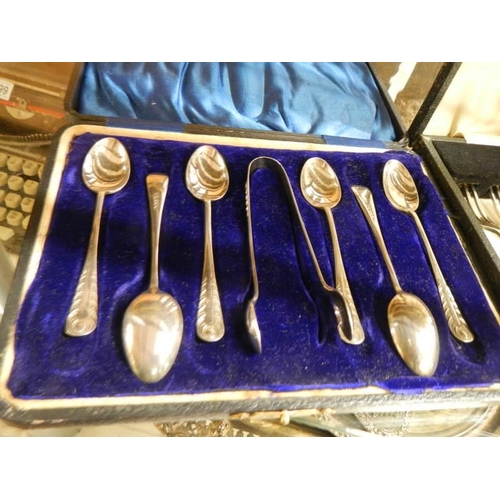 1298 - A cased set of dessert knives and forks and a cased set of teaspoons with sugar tongs.