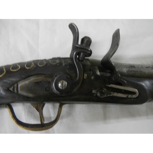 1329 - A 19th century flint lock pistol with brass inlay.