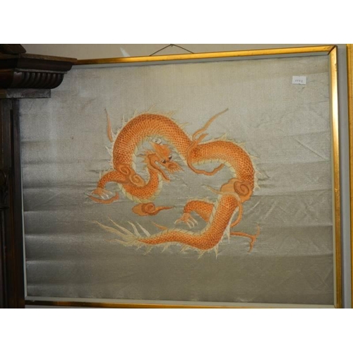 1366 - A pair of framed and glazed embroideries on silk of dragons.