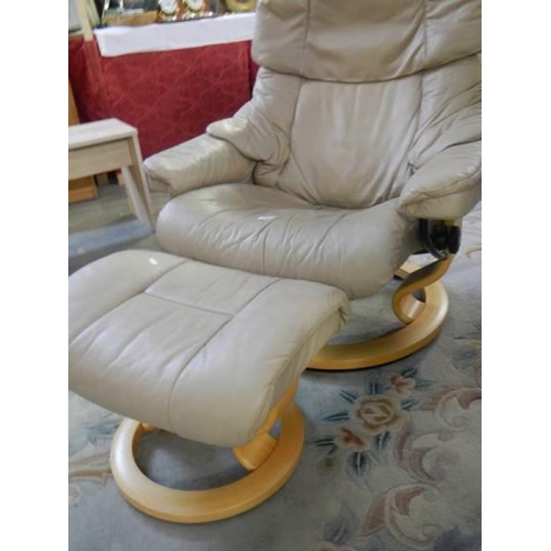 733 - A cream leather reclining chair with matching stool, COLLECT ONLY.