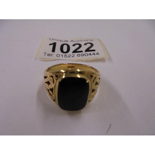 1022 - A yellow metal ring set black onyx, size R half. 68gms