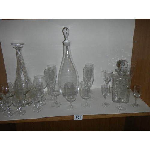 701 - Three glass decanters and a quantity of drinking glasses.