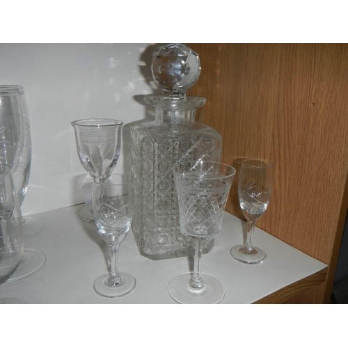 701 - Three glass decanters and a quantity of drinking glasses.