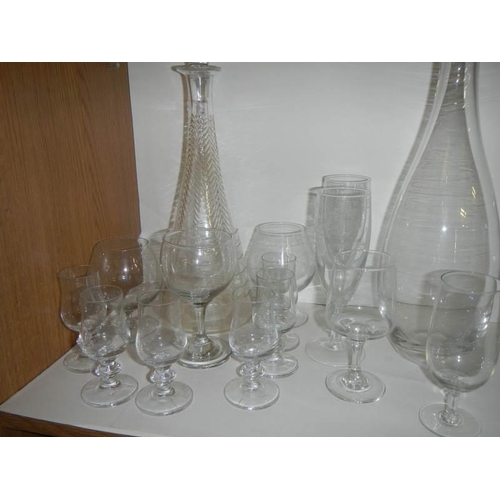 701 - Three glass decanters and a quantity of drinking glasses.