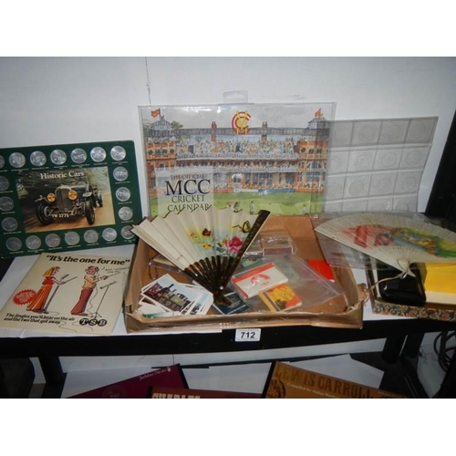 712 - A shelf of assorted matchboxes, coins, fans etc.,