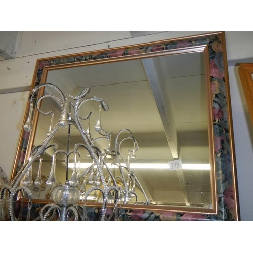 719 - A bevel edged mirror in fancy coloured frame. COLLECT ONLY,.