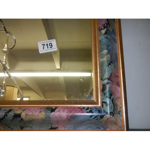 719 - A bevel edged mirror in fancy coloured frame. COLLECT ONLY,.