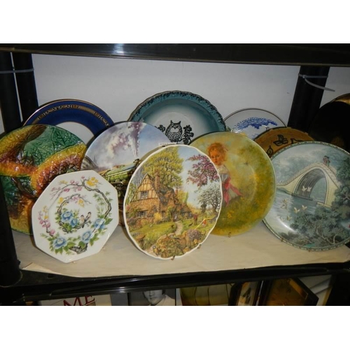 723 - A shelf of assorted collector's plates.