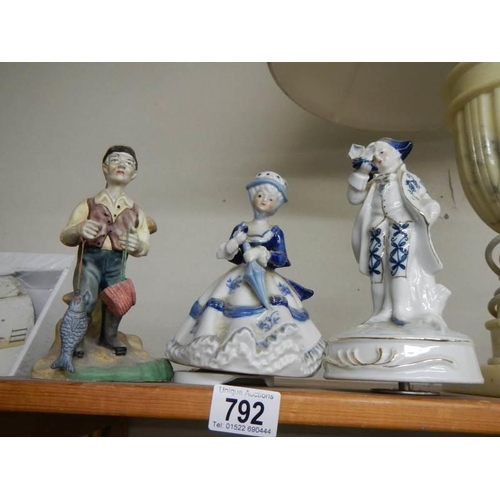 792 - A figure of a fisherman and two blue and white figures.