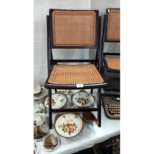 85 - 2 bergère panelled folding chairs. COLLECT ONLY