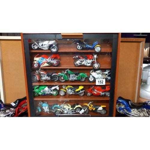 152 - A collection of plastic motorbike models including a display case