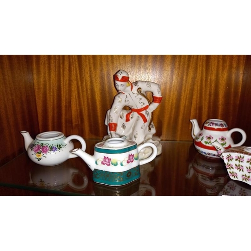 353 - A USSR Russian pottery figure of a female with a frog and 4 small teapots (all missing lids)