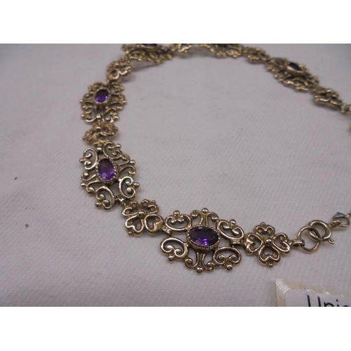 2065 - A 9ct gold bracelet set amethysts with safety chain and padlock, 15.1 grams total.