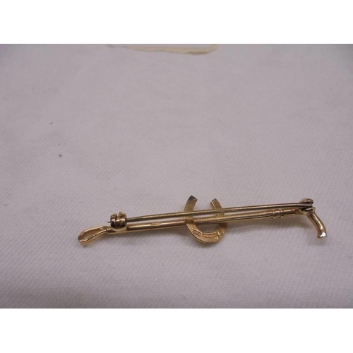 2066 - A 9ct gold brooch in the form of a riding crop and horse shoe, 3.3 grams.