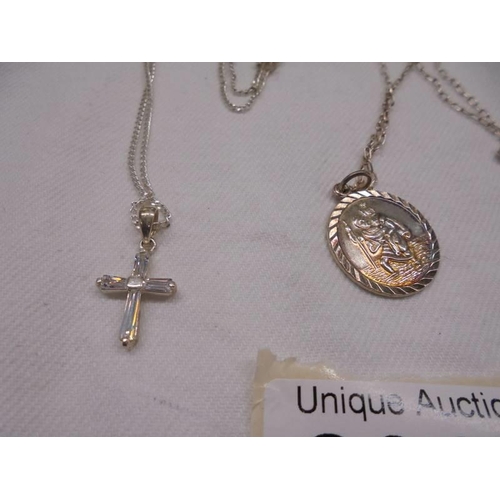 2068 - A silver St. Christopher on chain and a silver cross on chain, 6.2 grams.