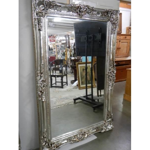 2661 - A large bevel edged mirror in silver gilded double swept frame, 125 x 185 cm. COLLECT ONLY.