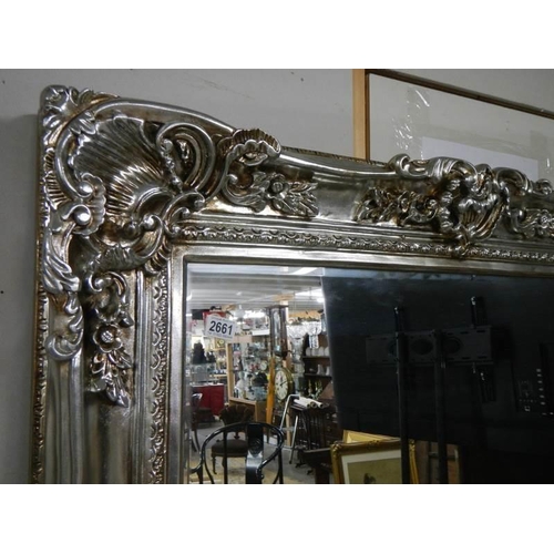 2661 - A large bevel edged mirror in silver gilded double swept frame, 125 x 185 cm. COLLECT ONLY.