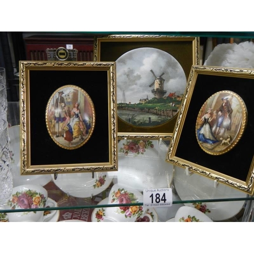 184 - Two gilt framed oval plaques and a gilt framed windmill scene.