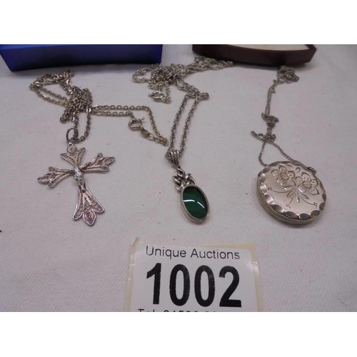 1002 - Three silver pendants, a silver locket and a silver (800) crucifix.