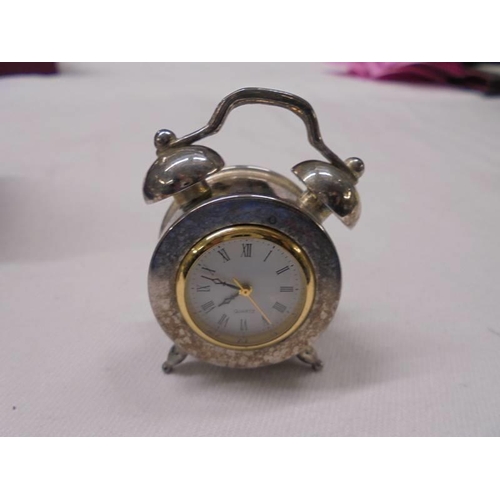 1027 - A cased miniature alarm clock.