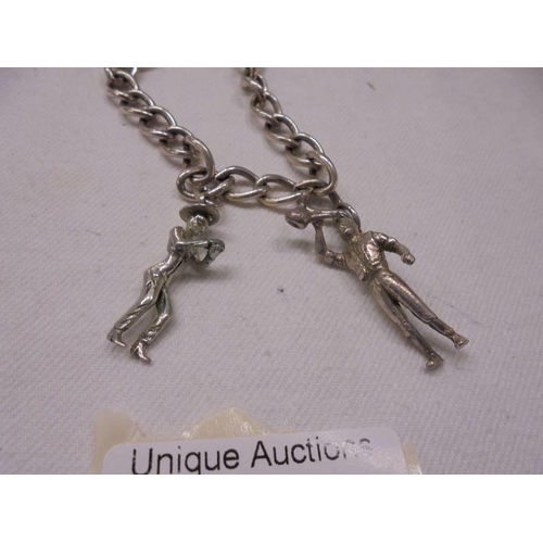 1033 - A silver charm bracelet with two figural charms, 18 grams.