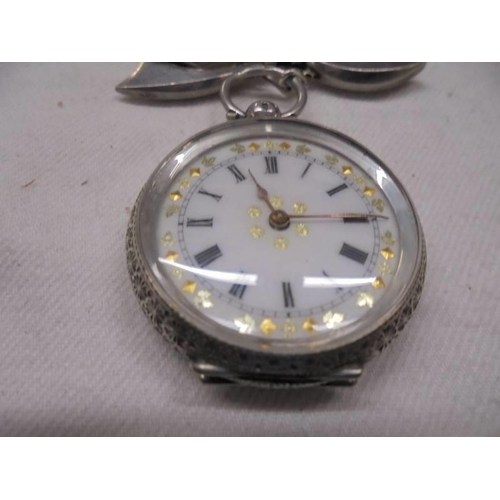 1047 - A Victorian ladies silver fob watch on a white metal bow pin.