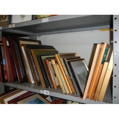 1392 - A large lot of pictures and frames on two shelves, COLLECT ONLY.