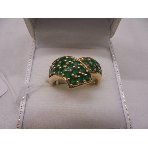 1134 - A 9ct gold ring set green stones, size S, 5.5 grams.