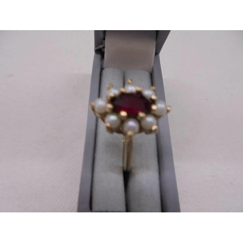 1146 - A vintage oval ring set with pearks and garnet, stamped 10 ct, Size L, 3.2 grams.