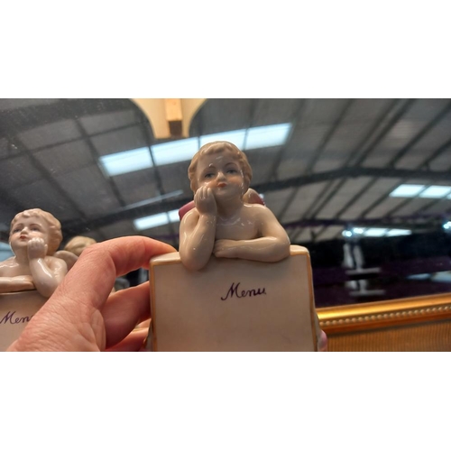 18 - A pair of continental bisque winged cherub menu holders