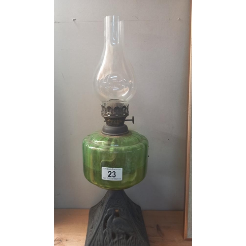 23 - A Victorian oil lamp with green glass font and cast iron base