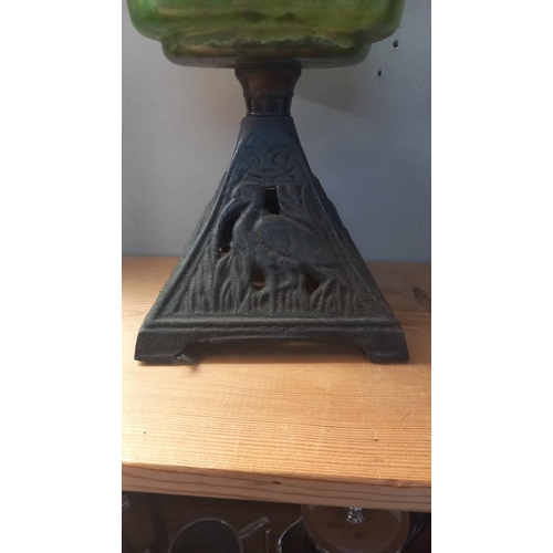 23 - A Victorian oil lamp with green glass font and cast iron base