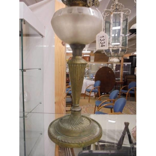 1334 - An oil oil lamp on metal base with glass font and complete with shade and chimney, COLLECT ONLY.