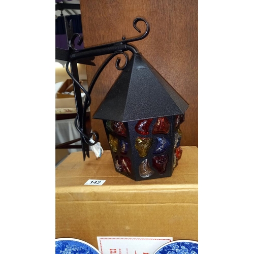 142 - An unused vintage boxed Da Vinci Pebble outside lantern with multi-coloured glass and wrought iron b... 