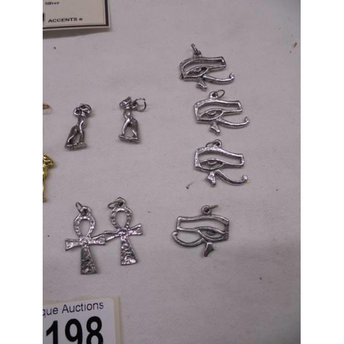 1198 - A quantity of Egyptian pendants including 2 silver Goddess Bastet, Eye of Horus etc.,