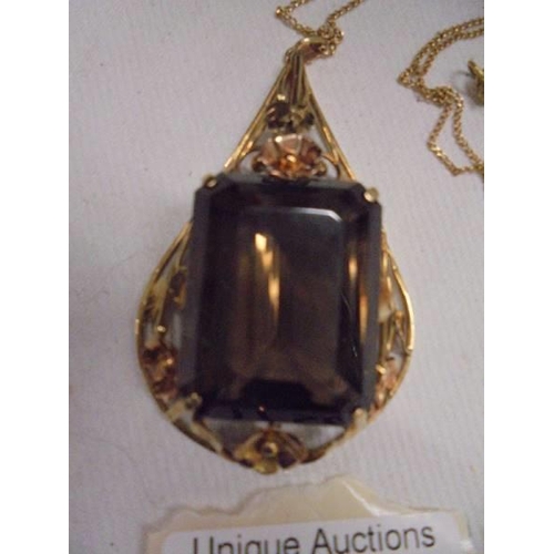 1150B - An 18c gold pendant set large stone (possibly smoky quartz) and a 750 gold chain.