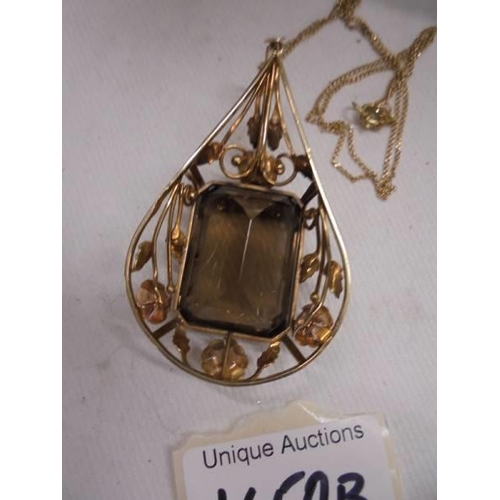 1150B - An 18c gold pendant set large stone (possibly smoky quartz) and a 750 gold chain.